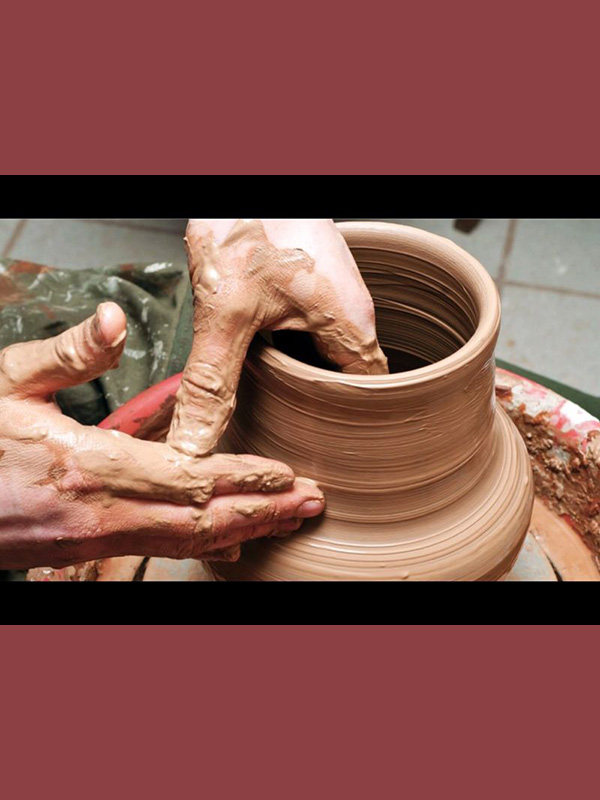 Hands working clay on a pottery wheel.