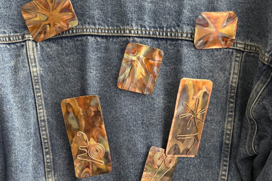 Heated copper pins on display jean jacket by Denny Young at the Somerset Artists' Co-Op.