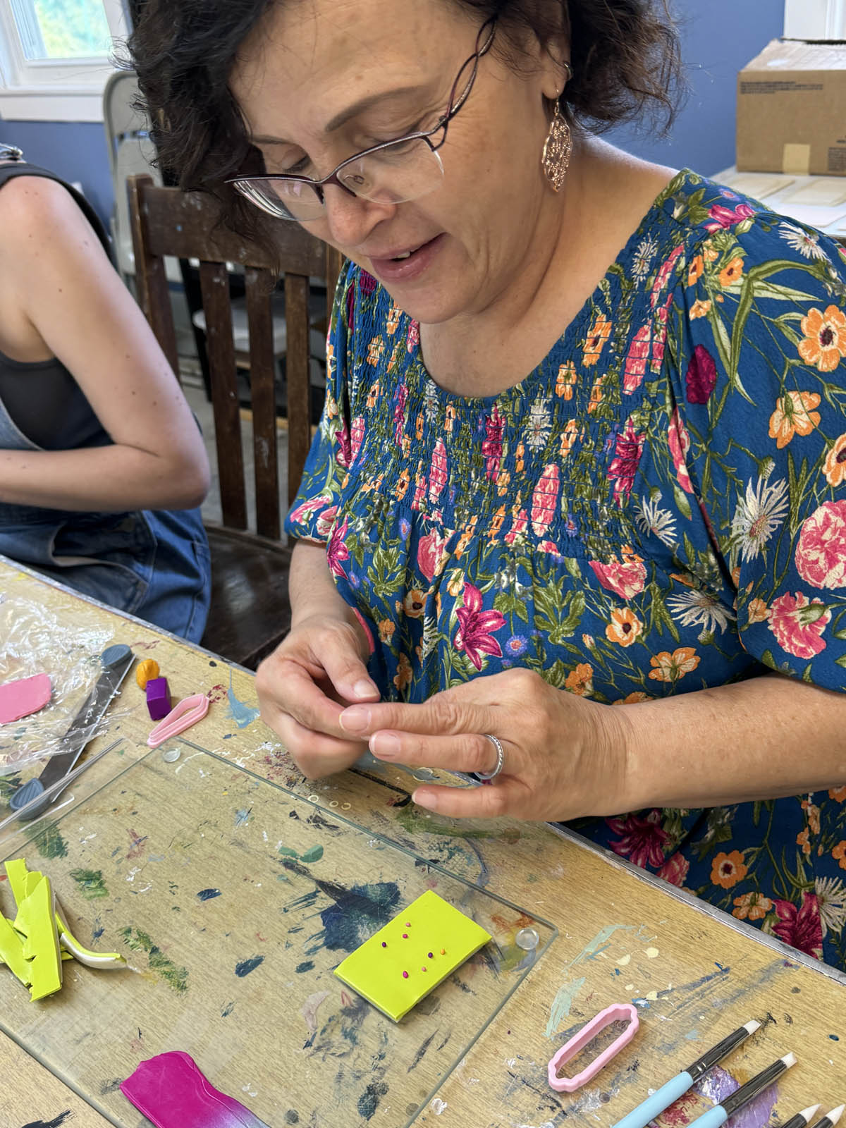 Student working on polymer clay earring design at the Somerset Artists' Co-Op.