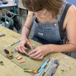 Student working on polymer clay earring design at the Somerset Artists' Co-Op.