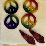 Polymer clay earrings and peace sign pendants after oven curing at the Somerset Artists' Co-Op.