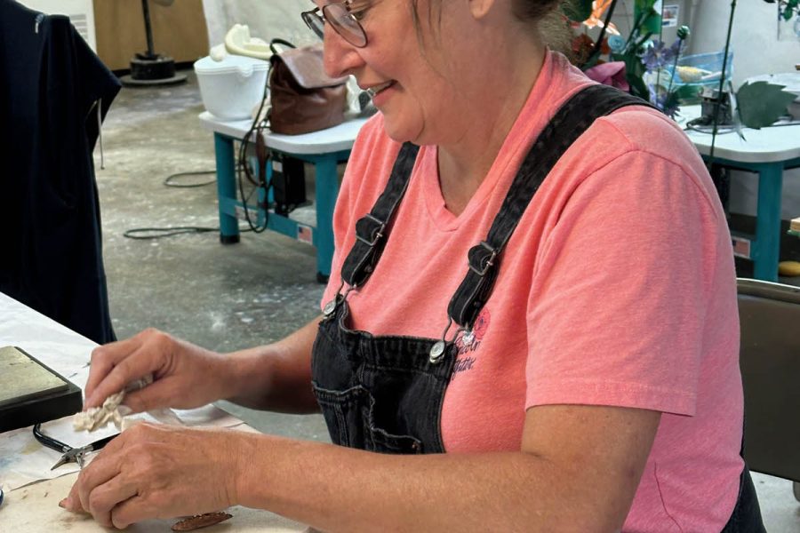 Student creating a pair of copper fold-formed earrings created in class at the Somerset Artists' Co-Op in Somerset, Ohio.