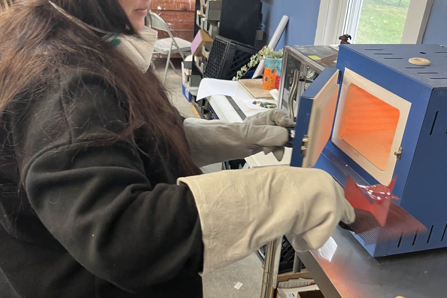 Introduction to Enameling student placing her piece in the enameling kiln at the Somerset Artists' Co-Op