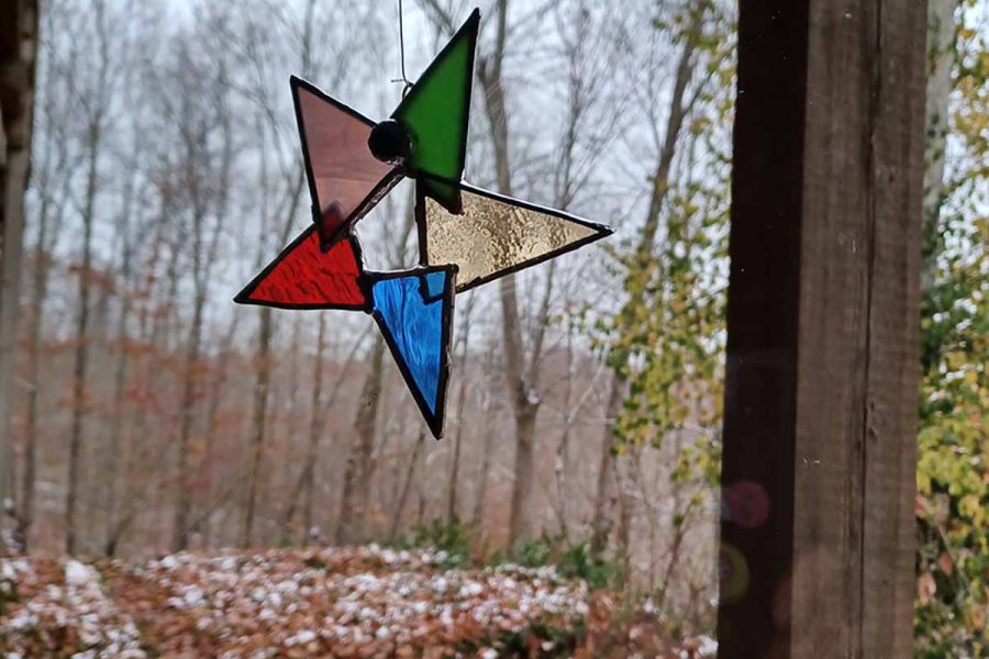 Tiffany-style stained glass star hanging in window on a winter's day.