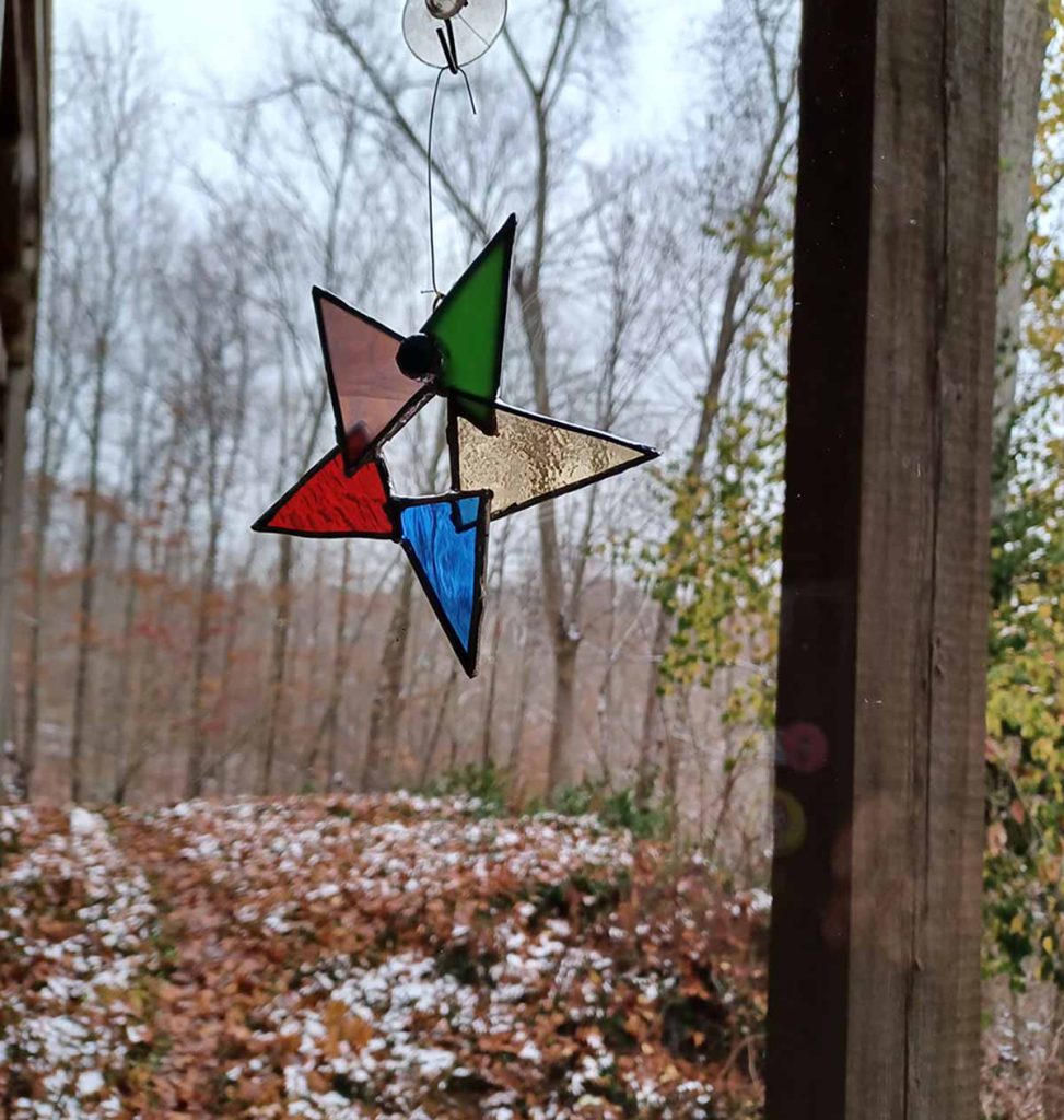 Tiffany-style stained glass star hanging in window on a winter's day.